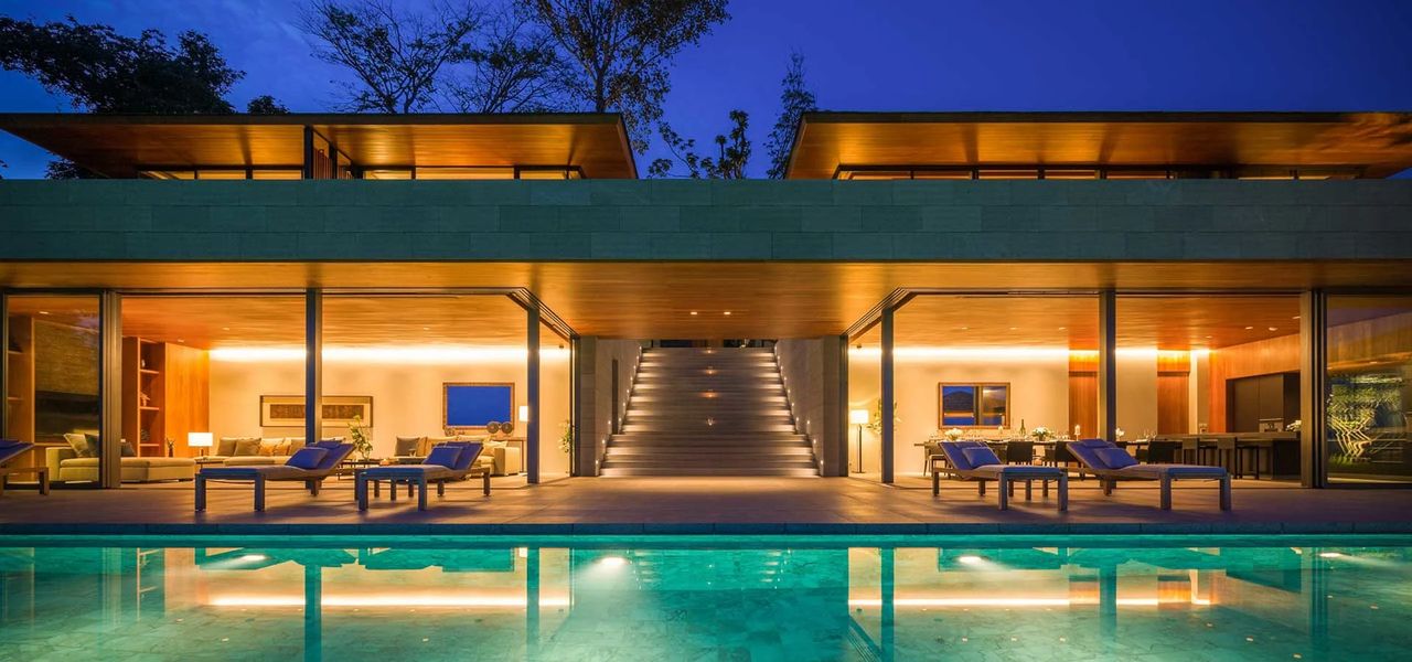 Avadina Hills villa glowing above its pool at night